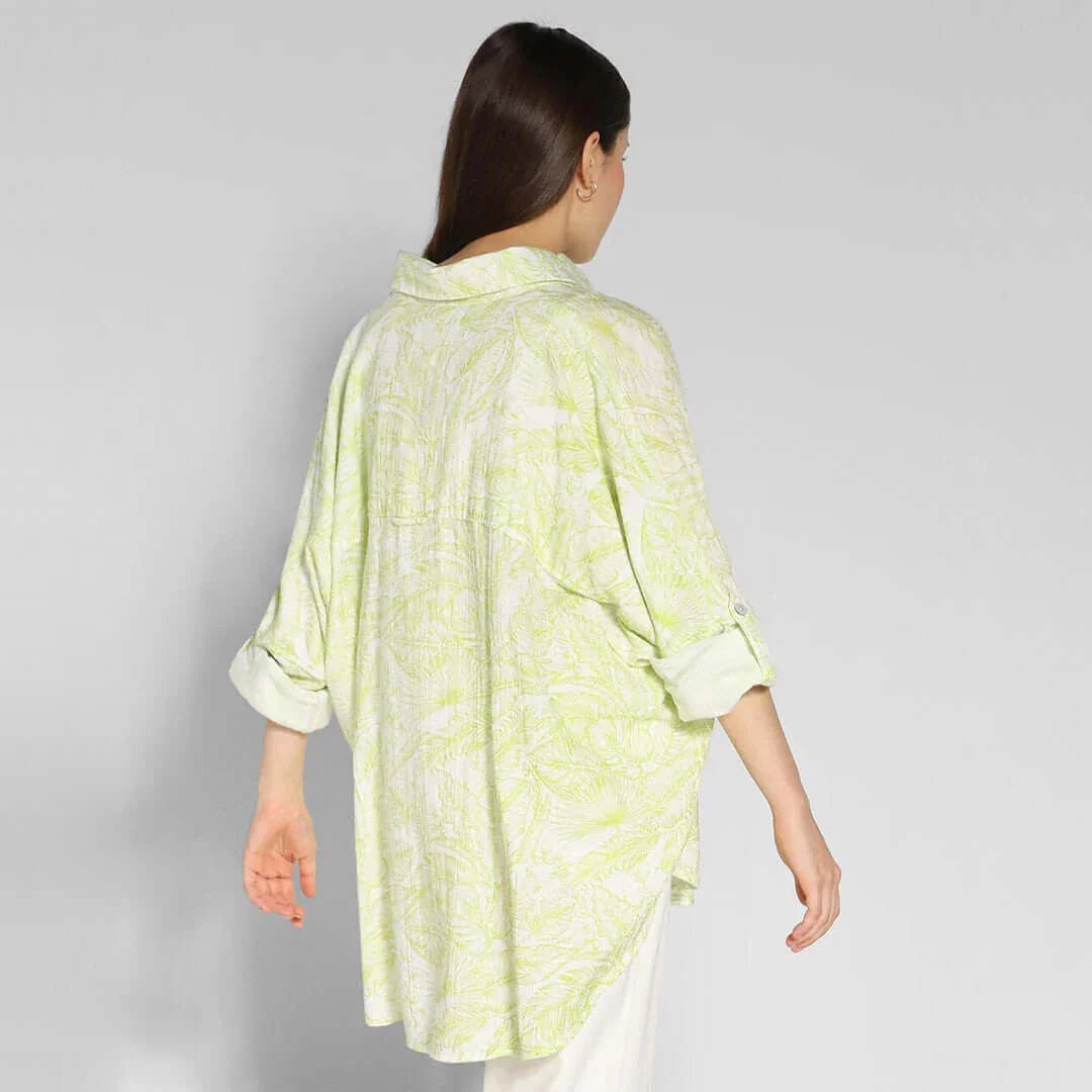 Back view of a woman wearing an oversized, printed American Eagle shirt in light green and white, showcasing its relaxed fit.